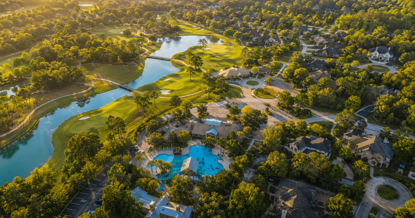Aerial view of Woodforest community in Montgomery TX showing golf course, resort pool, and mature trees at golden hour