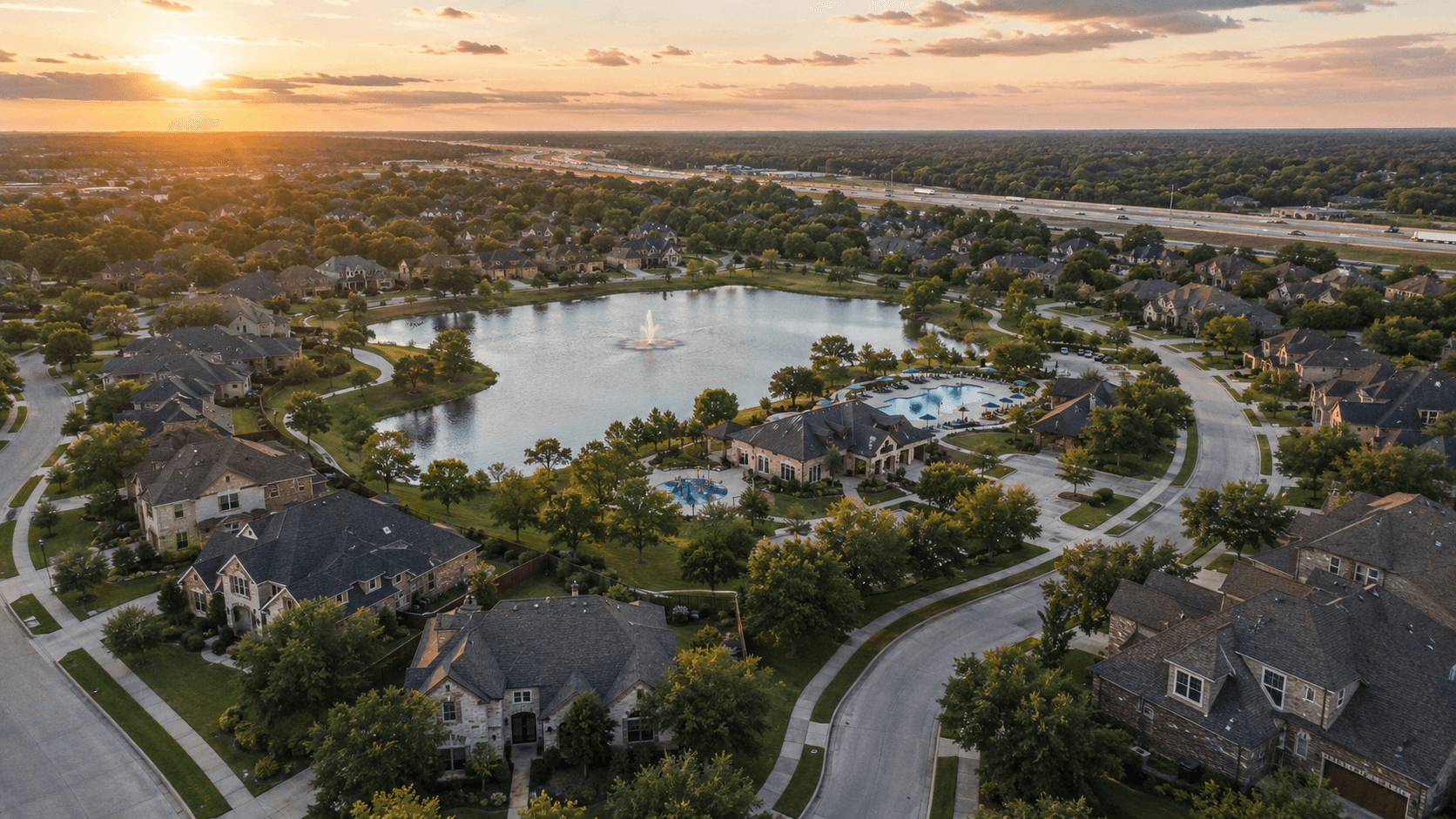 Aerial view of Bridgeland master-planned community in Cypress Texas showing lakes, trails, and new construction homes at golden hour