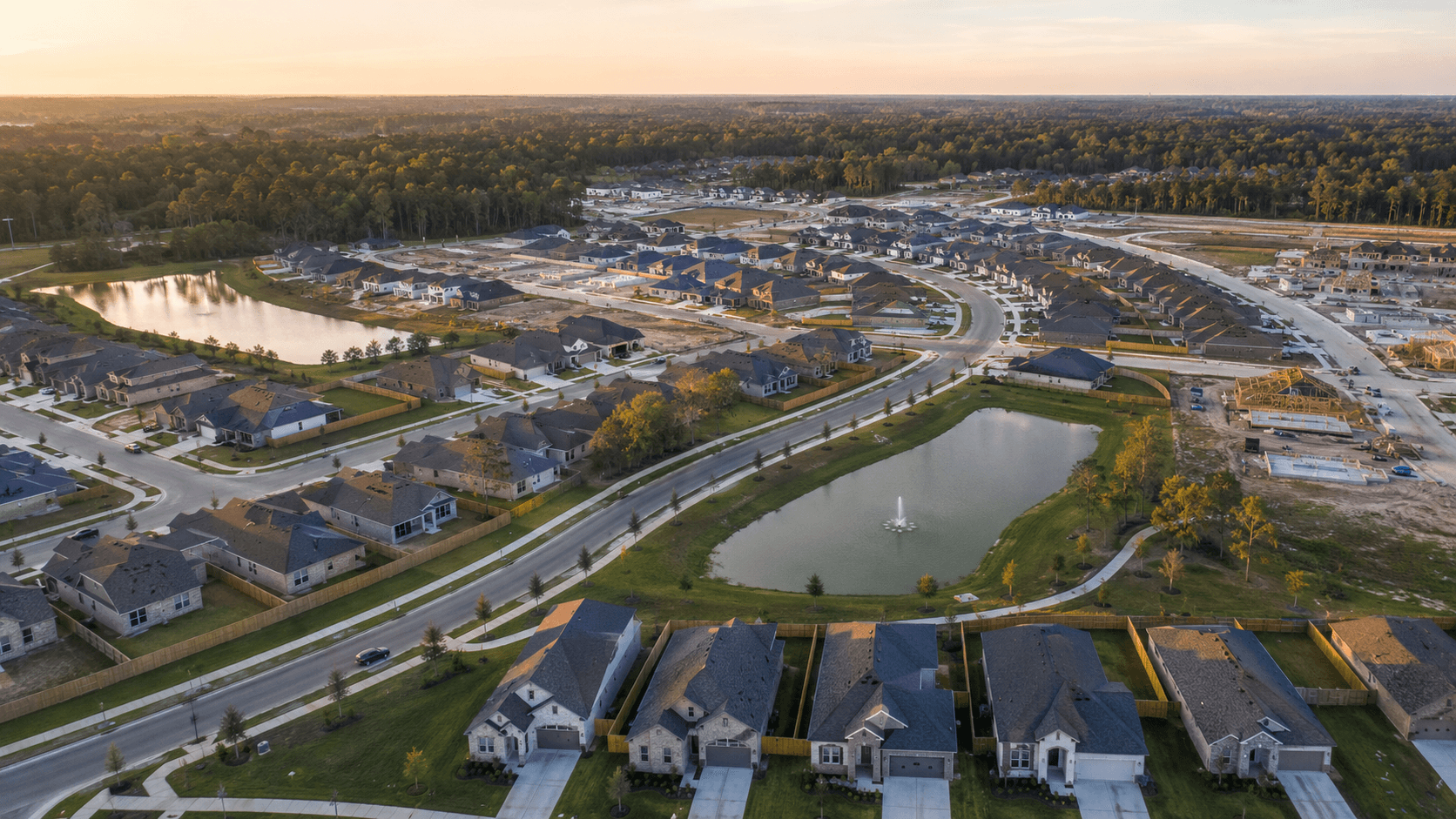 Aerial view of Cielo new construction community in Conroe TX at sunset with lake and homes under construction